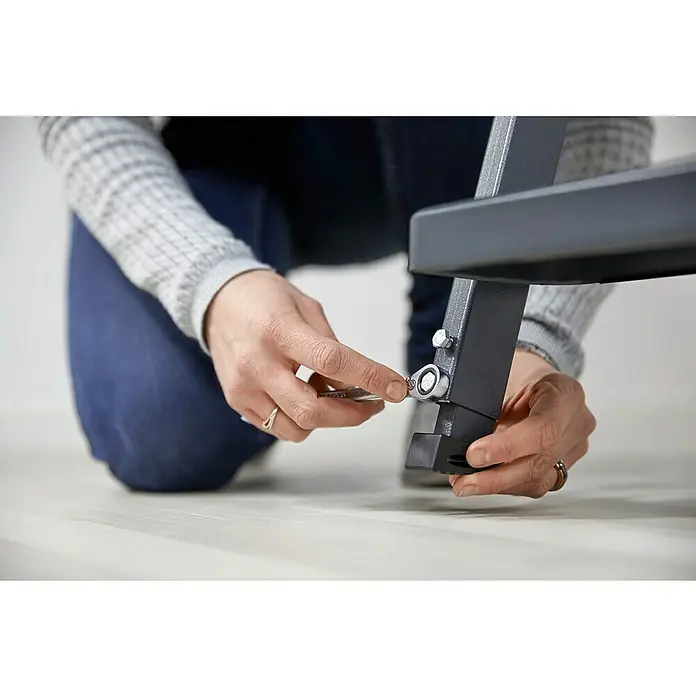Sogem Escalera escamoteable Isoclic Pro Confort - 120 x 60 cm, Aislamiento térmico: 0,49 W/(m²K) - Una persona ensamblando un mueble con una llave, enfatizando el proceso de ensamblaje del mueble.