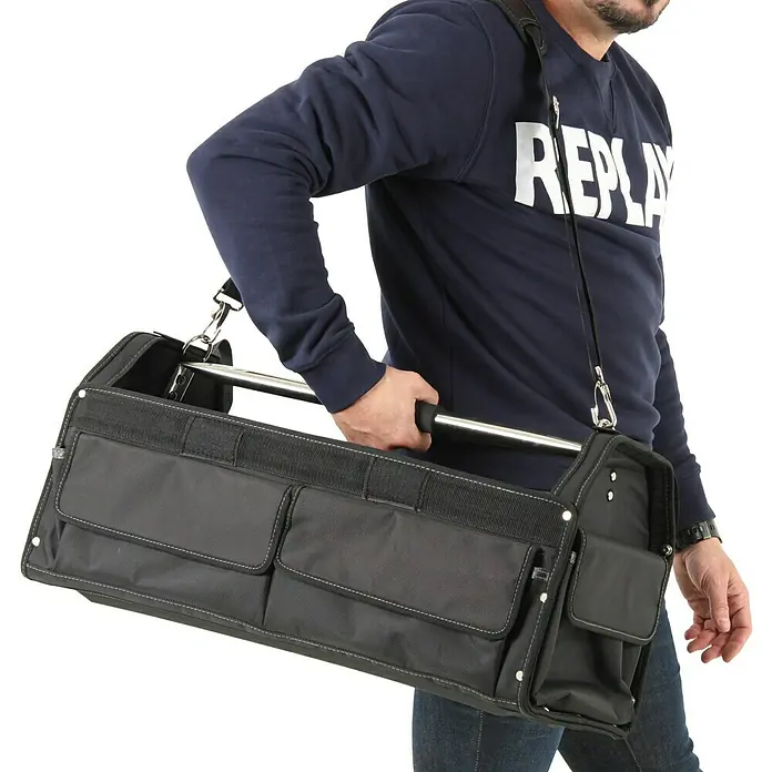 Hepco & Becker Werkzeugtasche Profi-Installateurtasche 5857 - L x B x H: 290 x 620 x 310 mm, Polyester - Eine schwarze Werkzeugtasche mit Tragegriff und Schultergurt wird von einer Person getragen.