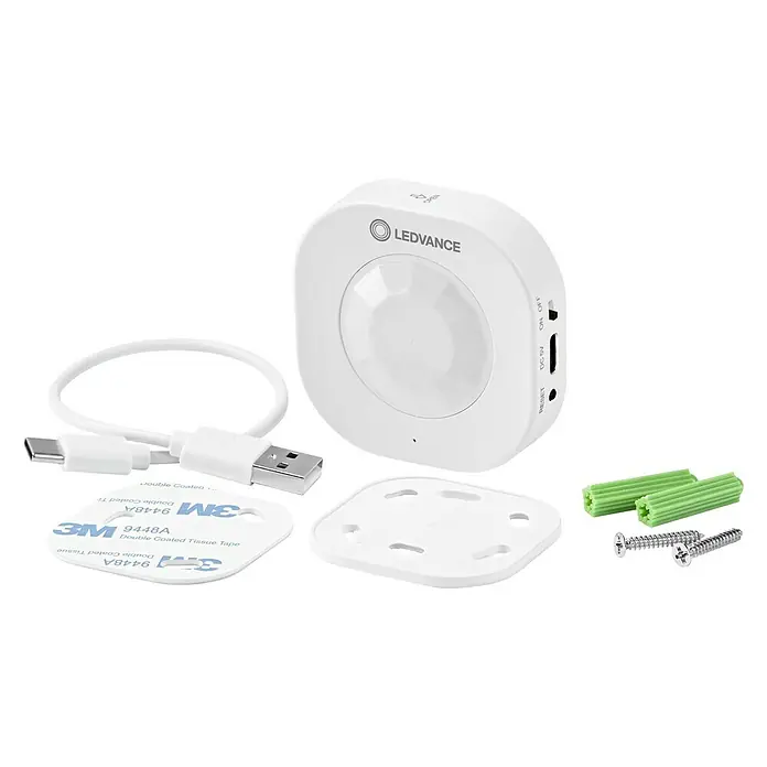 Ledvance Smart+ WiFi Bewegungsmelder - Weiß, L x B x H: 6,03 x 2,05 x 6,03 cm - Nahaufnahme eines LEDVANCE Bewegungsmelders mit USB-Kabel, Klebestreifen und Montagezubehör für die Wandbefestigung.
