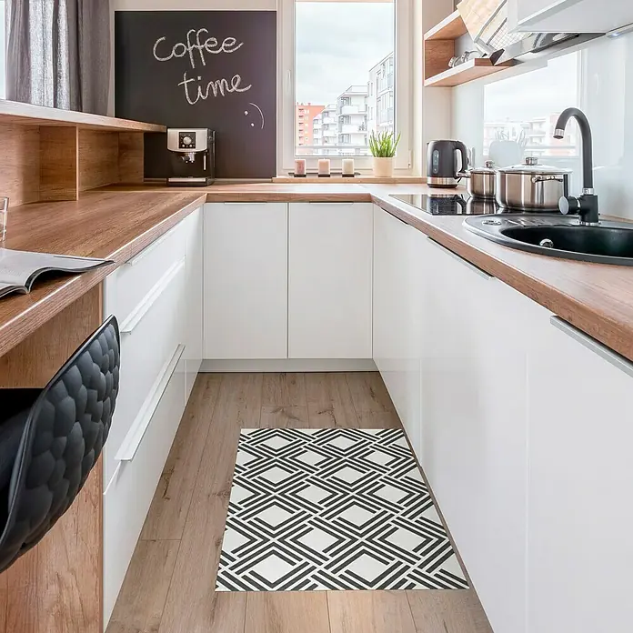 Alfombra de vinilo Living geométrica - Negro, 90 x 60 cm - Alfombra de cocina moderna con estampado geométrico en una cocina luminosa con suelos de madera y armarios blancos.