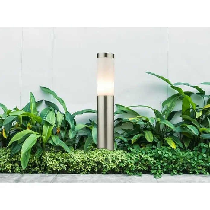 Globo Boston Sobremuro exterior 45 - 60 W, Color del marco: Plateado, 12,7 x 12,7 x 45 cm, Sin bombillas - Baliza iluminada de acero inoxidable entre exuberante vegetación, ofreciendo iluminación ambiental para jardines.