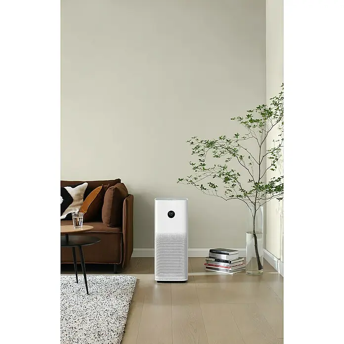 Xiaomi Luftreiniger Smart Air Purifier 4 Pro - L x B x H: 27,5 x 27,5 x 68 cm, Filtert bis zu 99,97 % aller Schadstoffe in einer Größe von 0,3 Micrometer - Bild eines modernen Luftreinigers in einem stilvollen Wohnzimmer, neben einem Sofa und einer Pflanze.