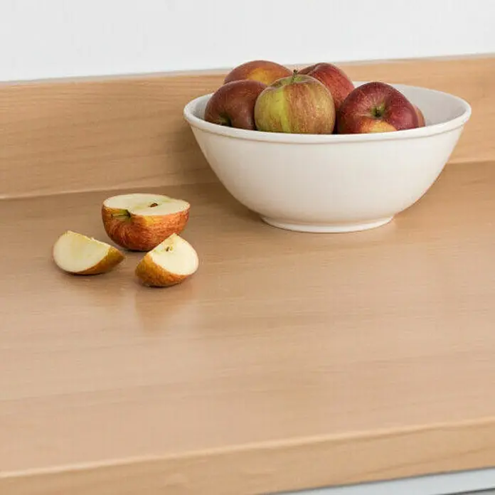 D-c-fix Lámina efecto madera - Haya, 210 x 90 cm, Madera de haya, Autoadhesivo - Primer plano de un tazón de manzanas y rodajas de manzana en una superficie de madera clara, que muestra la belleza natural y la frescura de la fruta.