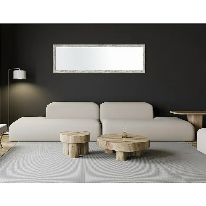 Espejo de pared Lincoln - 45 x 147 cm, Gris - Un elegante salón con un gran espejo rectangular enmarcado sobre un moderno sofá, que realza el espacio visual de la habitación.