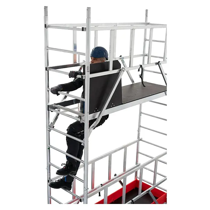 Krause Belagbühne PROTEC XXL - 2 x 0,6 m, mit Luke - Ein Bauarbeiter klettert auf ein Layher Uni Standard Fahrgerüst, das vielseitig für Arbeiten in der Höhe einsetzbar ist.