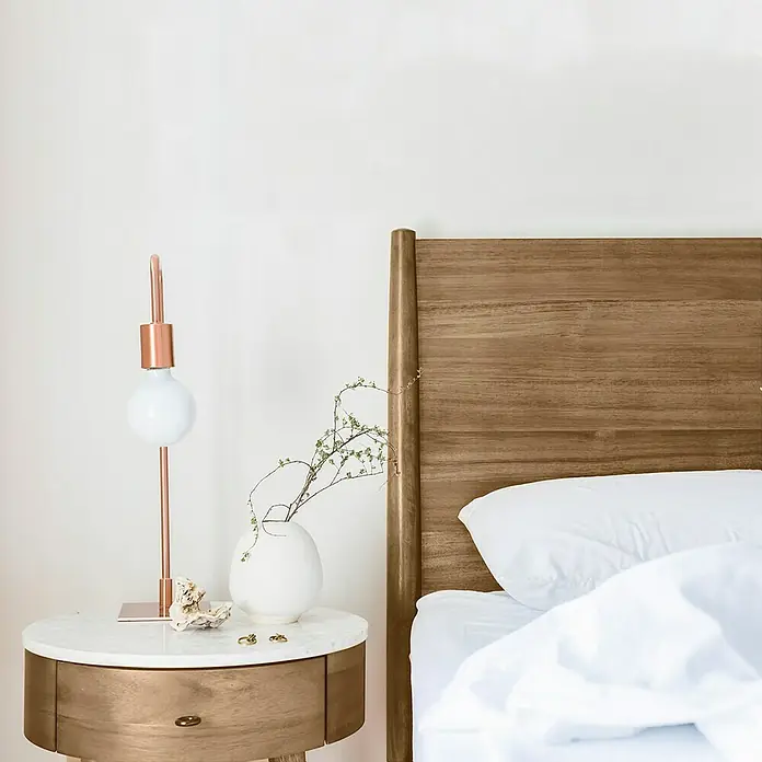 La Pajarita Pátina - Avellana, 75 ml, Mate - Un dormitorio elegante con una cama de madera y una mesita de noche con una lámpara moderna y decoraciones.