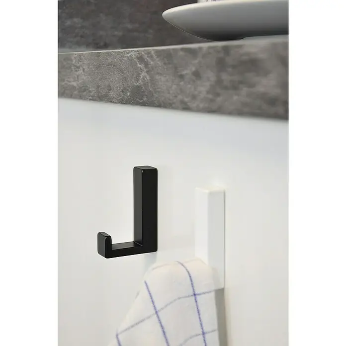Siro GarderobenhakenL x B x H: 15 x 61 x 40 mm, Anzahl Haken: 1 Stk., Weiß - Das Bild zeigt zwei Handtuchhaken, einen schwarzen und einen weißen, an einer weißen Wand mit einem Handtuch.