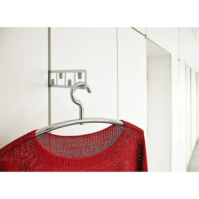 Siro Kleiderlüfter - L x B x H: 62 x 55 x 192 mm - Nahaufnahme eines roten Strickpullovers, der an einem modernen Chrombügel auf einer grauen Wandhalterung mit minimalistischem Design hängt.