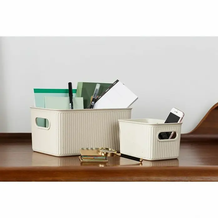 Tatay Baobab Cesta para la ropa - 29,4 x 38,5 x 16 cm, Plástico, Beige - Dos cajas de almacenamiento de plástico beige sobre una mesa, llenas de artículos de oficina como bolígrafos, notas y un smartphone.