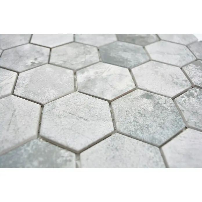 Mosaikfliese Hexagon HX CURIO ZLG - 32,5 x 28,1 cm, Grau, Matt - Nahaufnahme eines Musters aus sechseckigen, grau-weiß marmorierten Fliesen. Die Oberfläche zeigt dezente Farbvariationen, die ein elegantes und modernes Design erzeugen.