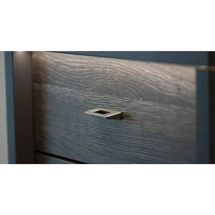 Siro Möbelknopf - Typ Möbelgriff: Knopf, Sonstige, Sonstige, Eisenfarben, Breite: 10 mm - Nahaufnahme eines grauen Holzschrankes mit einem quadratischen Metallgriff. Die Holzmaserung ist deutlich sichtbar und verleiht dem Möbelstück Charakter.
