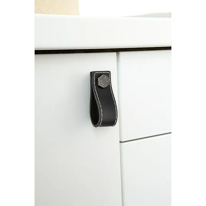 Siro Möbelgriff - Typ Möbelgriff: Sonstige, Sonstige, Sonstige, Schwarz, Breite: 75 mm - Nahaufnahme eines weißen Schranks mit einem schwarzen Ledergriff, der mit einem silbernen Bolzen befestigt ist, der dem Design einen industriellen Touch verleiht.