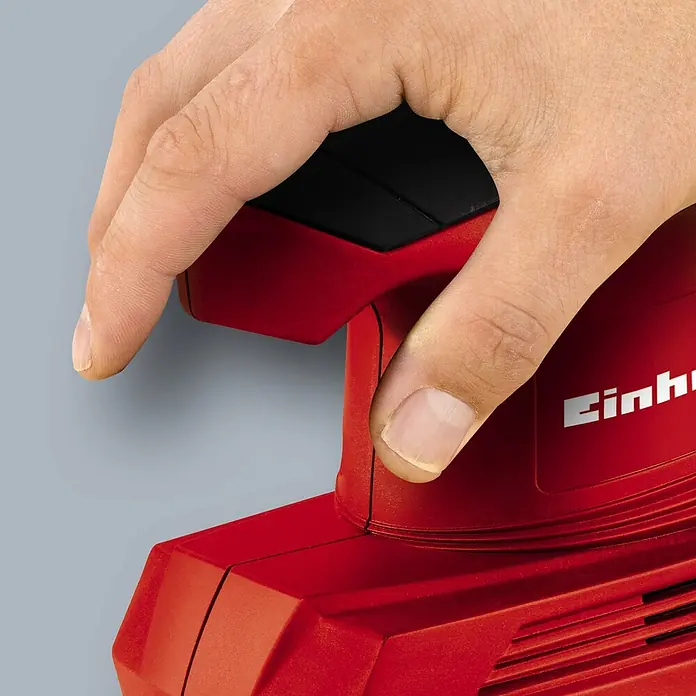 Einhell Classic Elektro-Schwingschleifer TC-OS 1520 - 150 W - Detailaufnahme eines roten Einhell Elektrowerkzeugs mit einer Hand, die den schwarzen Schalter betätigt.