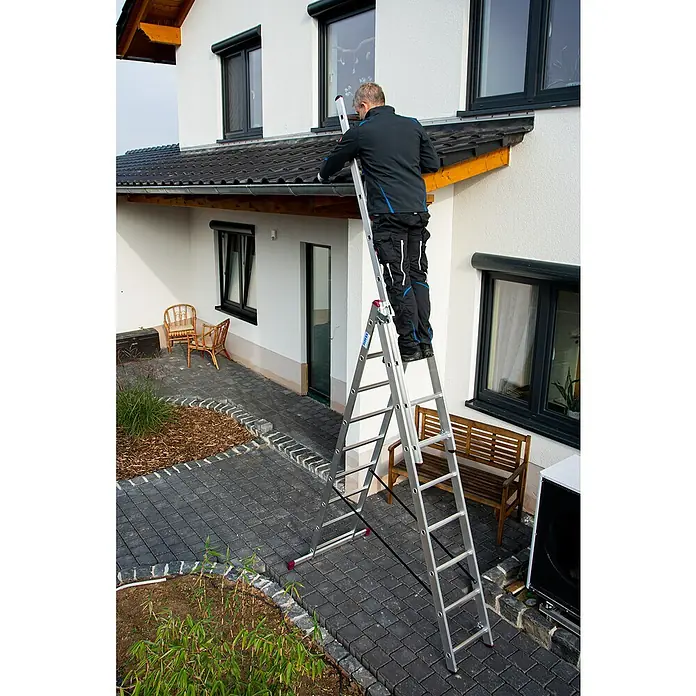 Krause Corda Mehrzweckleiter - Arbeitshöhe: 6,2 m, Anzahl Tritte: 27 Stk., Belastbarkeit: 150 kg, Aluminium - Mann steht auf einer Leiter, die an ein Haus gelehnt ist und arbeitet am Dach. Die Leiter ist aus Aluminium und hat rote Sicherheitsfüße.