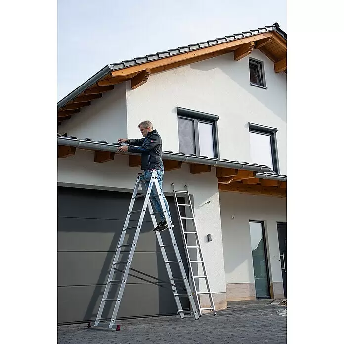 Krause Corda Mehrzweckleiter - Arbeitshöhe: 5,1 m, Anzahl Tritte: 21 Stk., Belastbarkeit: 150 kg, Aluminium - Mann reinigt Dachrinne an einem Haus mit einer silbernen Aluminiumleiter.