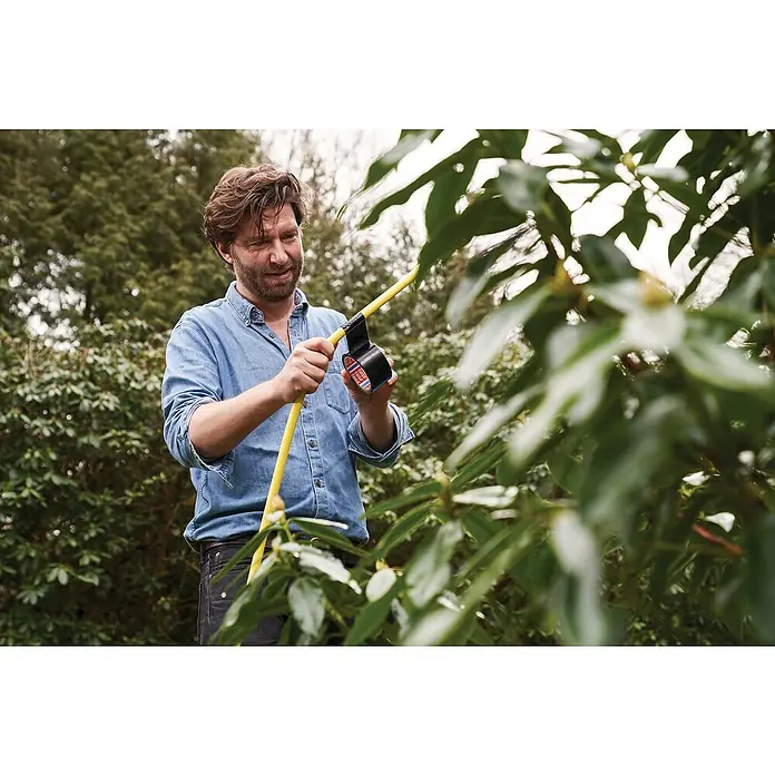 Tesa Extra Power Folienband Universal - Silber, 25 m x 50 mm - Ein Mann repariert einen gelben Gartenschlauch mit Tesa Gewebeband im Garten, umgeben von üppigem Grün.