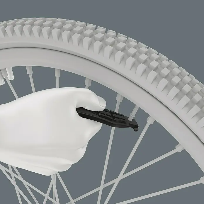 Wera Reifenheber Bicycle Set 15 - Geeignet für: Zweiräder, 5 -tlg. - Ein Reifenheber wird an einem Fahrradreifen verwendet, wobei die Konstruktion des Reifens gut sichtbar ist.