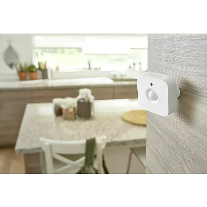Philips Hue Bewegungsmelder - Weiß, L x B x H: 2 x 5,5 x 5,5 cm - Der Philips Hue Bewegungssensor ist an einer Wand in einer Küche montiert, um die Beleuchtung automatisch zu steuern.