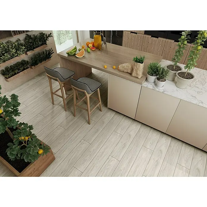 LOGOCLIC Laminado Nogal Sintra - 1.380 x 193 x 8 mm, AC5 - Cocina luminosa con suelos de madera, dos taburetes de bar, una encimera con plantas y fruta fresca para un aspecto moderno.