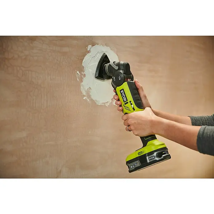 Ryobi ONE+ Maschinenpaket - Akku-Multifunktionswerkzeug R18MT-0 + gratis Starter-Kit - Ein Ryobi ONE+ Akku-Multifunktionswerkzeug wird zum Glätten von Spachtelmasse an einer Wand verwendet. Das Werkzeug ist grün und schwarz.