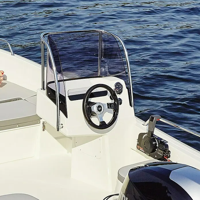 PEGAZUS Steuerstand - Passend für: Pegazus Boot GFK 450 - Das Steuerrad und die Windschutzscheibe eines weißen Motorboots im Detail. Das Boot befindet sich auf dem Wasser.