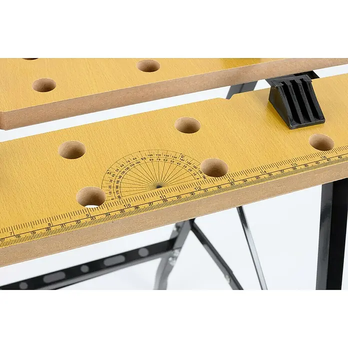 Banco de trabajo plegable - L x An: 56 x 62 cm, Altura de trabajo: 76 cm, Carga soportada: 100 kg - Primer plano de un banco de trabajo con agujeros, un transportador de ángulos y medidas, destacando su funcionalidad.