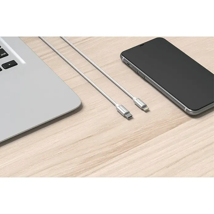 BAUHAUS USB-Kabel - 1 m - Nahaufnahme eines USB-C-auf-Lightning-Kabels, das neben einem Laptop und einem Smartphone auf einem Holztisch liegt.