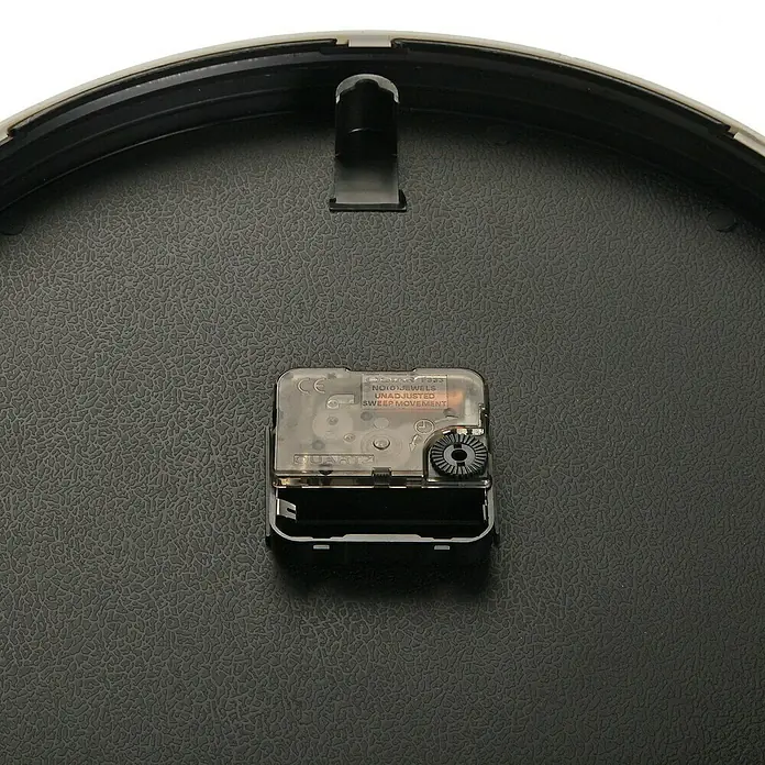 Versa Reloj de pared Clásico - Diámetro: 40 cm, 40 x 40 cm, Azul, Clásico - Primer plano del mecanismo de un reloj de pared. El movimiento de cuarzo asegura un cronometraje preciso.