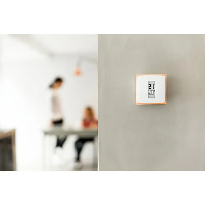 Netatmo Termostato inteligente - L x An x Al: 2,2 x 8,3 x 8,3 cm - Primer plano de un termostato digital en una pared, configurado a 21 grados Celsius, lo que garantiza una temperatura ambiente agradable.