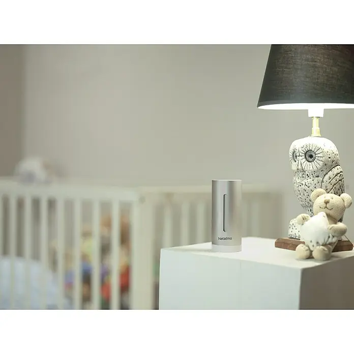 Netatmo Higrómetro módulo interior adicional - Funciona con pilas, Plateado, Ø x Al: 4,5 x 15,5 cm - Primer plano de una estación meteorológica interior Netatmo en una mesa con una lámpara y un juguete en una habitación infantil.