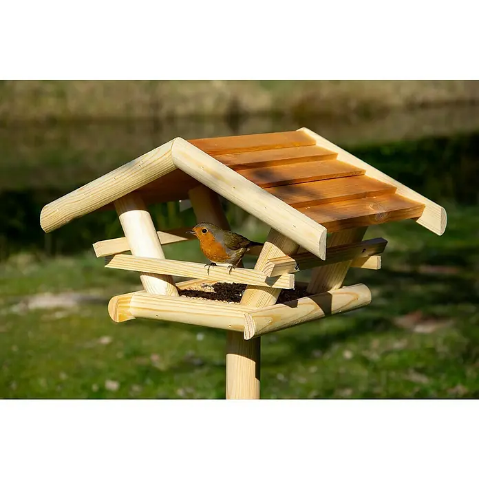 Dobar Vogelhaus Bernie Bernstein - 44 x 44 x 101 cm, Holz, Braun - Ein hölzernes Vogelhaus mit einem Rotkehlchen, das darauf sitzt. Das Vogelhaus ist mit Samen gefüllt und befindet sich in einem Garten.