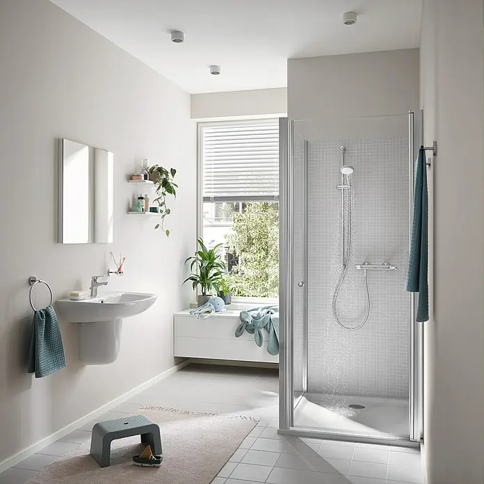 Grohe Brausethermostat Precision Flow - Chrom - Badezimmer mit moderner Duschkabine, Waschbecken und Spiegel. Das helle Design schafft eine freundliche Atmosphäre im Raum.