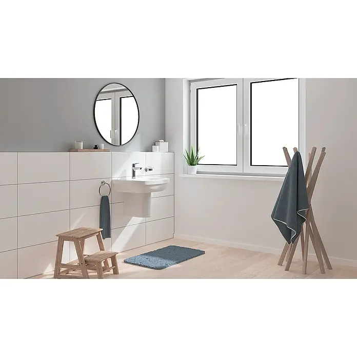 Grohe Start Grifo de lavabo M - Cromo, Resplandeciente, Barra de tracción - Un baño con un lavabo elegante, un espejo redondo y una ventana que aporta luminosidad.