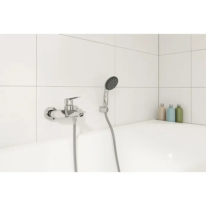 Grohe Start Grifo monomando de bañera + conjunto ducha -  - Grifo de baño con grifo cromado y teleducha sobre una pared de azulejos blancos sobre una bañera.