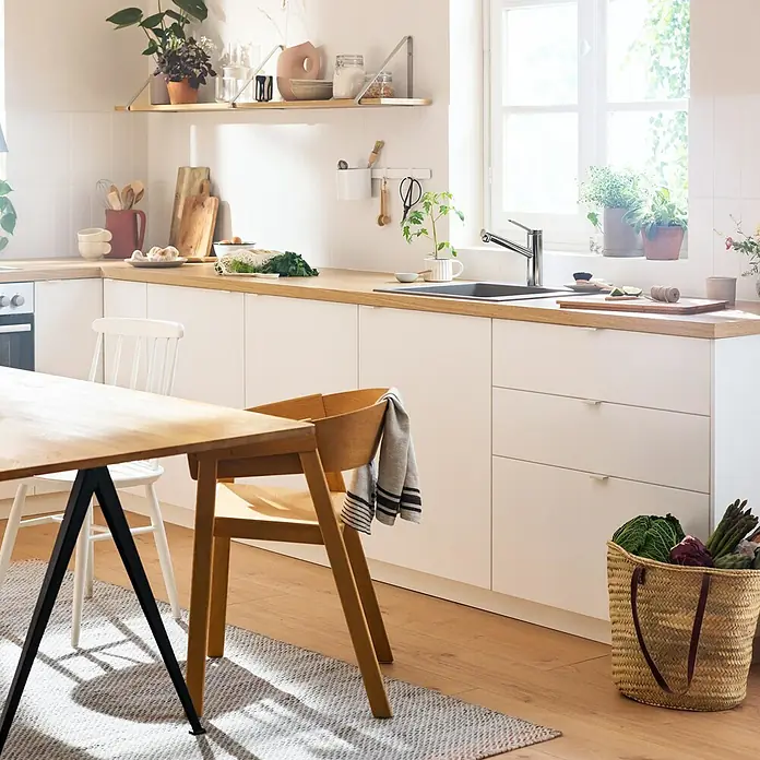 Hansgrohe Grifo de cocina Zesis - Cromo, Brillante, Giratoria - Cocina luminosa con encimera de madera y armarios blancos modernos. El foco está en el ambiente acogedor y aireado.