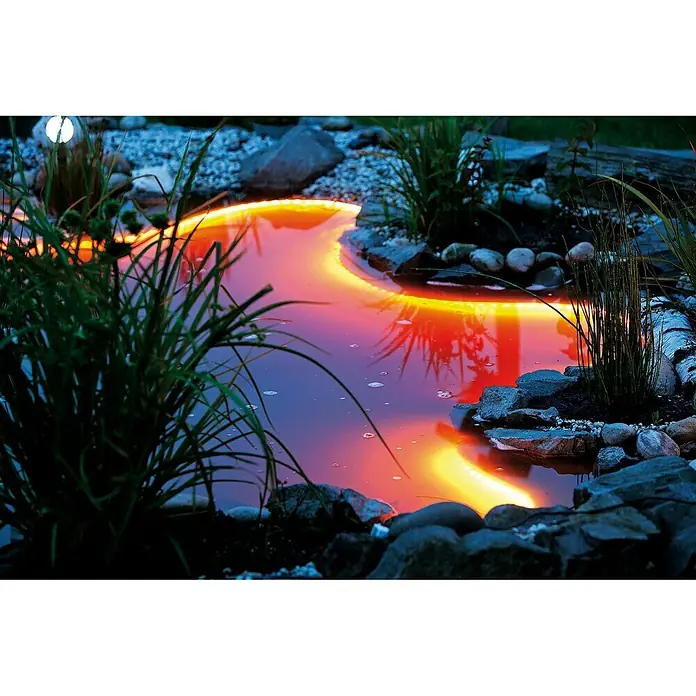 Heissner LED-Band Unterwasser - 5 m - Diese Aufnahme zeigt einen illuminierten Teich mit Pflanzen und Steinen. Die Beleuchtung erzeugt eine warme Atmosphäre.