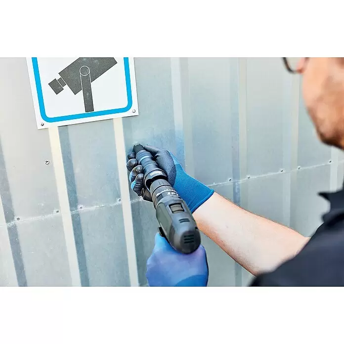Rapid Nietmutter-Adapter RP160 - Geeignet für: Akkuschrauber/Bohrmaschinen - Person in blauen Handschuhen benutzt ein dunkles Befestigungswerkzeug an einer Wellblechwand.