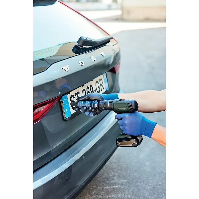 Rapid Blindnietvorsatz RP150 Multi™ - Geeignet für: Akkuschrauber/Bohrmaschinen - Ein Mann befestigt mit einem Akkuschrauber ein Nummernschild an einem grauen Volvo. Das Nummernschild trägt die Aufschrift "ST-269-GR".