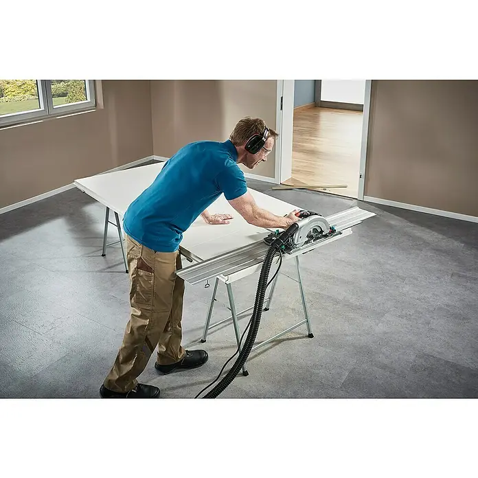 Wolfcraft Guía de carril FKS 145 - L x An x Al: 145 cm x 19 cm x 1,2 mm, Aluminio - Un artesano utiliza una sierra de calar con guía para cortar un panel blanco sobre un banco de trabajo en una habitación.