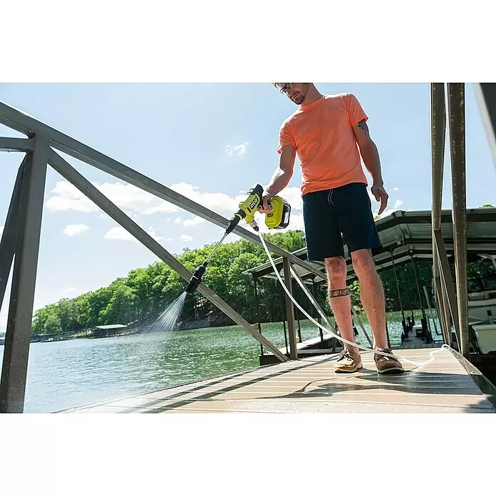 Ryobi ONE+ Akku-Hochdruckreiniger RY18PWX41A-0 - 18 V, Ohne Akku, Max. Druck: 41 bar - Mann reinigt einen Holzanleger am See mit einem limettengrünen Ryobi Akku-Hochdruckreiniger.