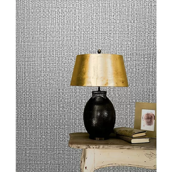 Marburg Vintage Deluxe Vliestapete Retro - Grau-Silber, Uni, 10,05 x 0,53 m - Graue Tapete mit gewebter Textur in einem Raum mit Lampe und Tisch.