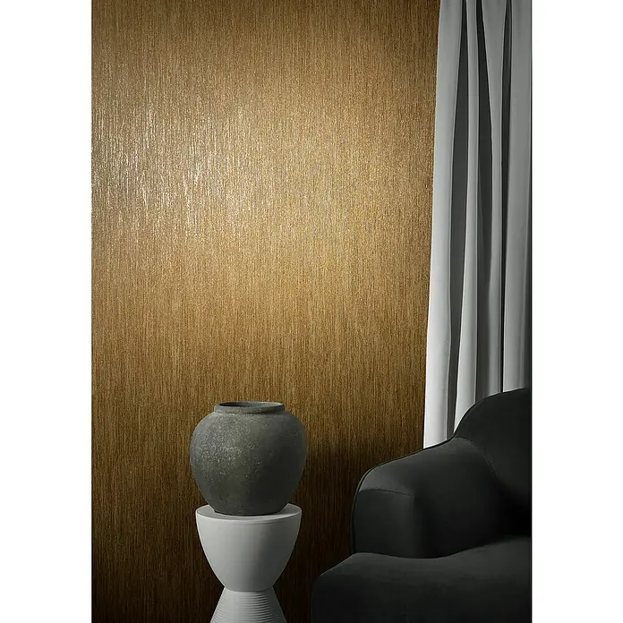 Marburg Natural Opulence Vliestapete - Braun, Streifen, 10,05 x 0,7 m - Eine Nahaufnahme eines stilvollen Wohnzimmers mit einer grauen Couch, einem Steinhocker und einer eleganten Vase vor einer strukturierten Wand.