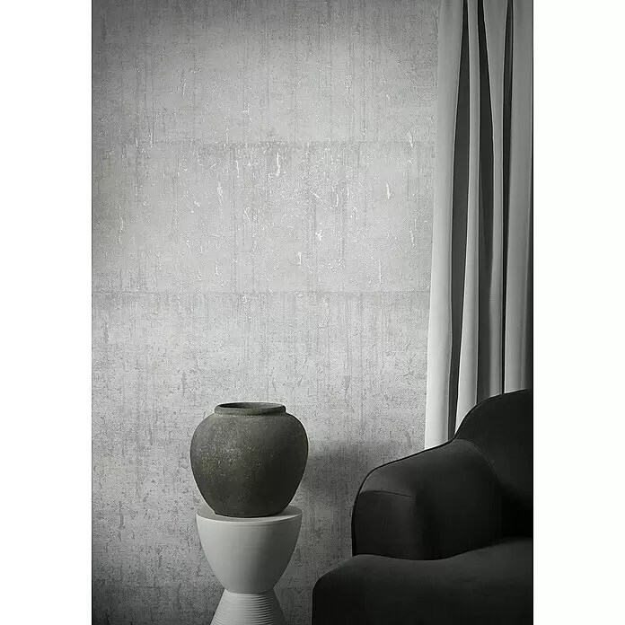Marburg Natural Opulence Vliestapete - Weiß I, Betonoptik, 10,05 x 0,7 m - Graue texturierte Wandverkleidung, eine dunkle Dekovase auf weißem Sockel, ein Sessel und ein grauer Vorhang.