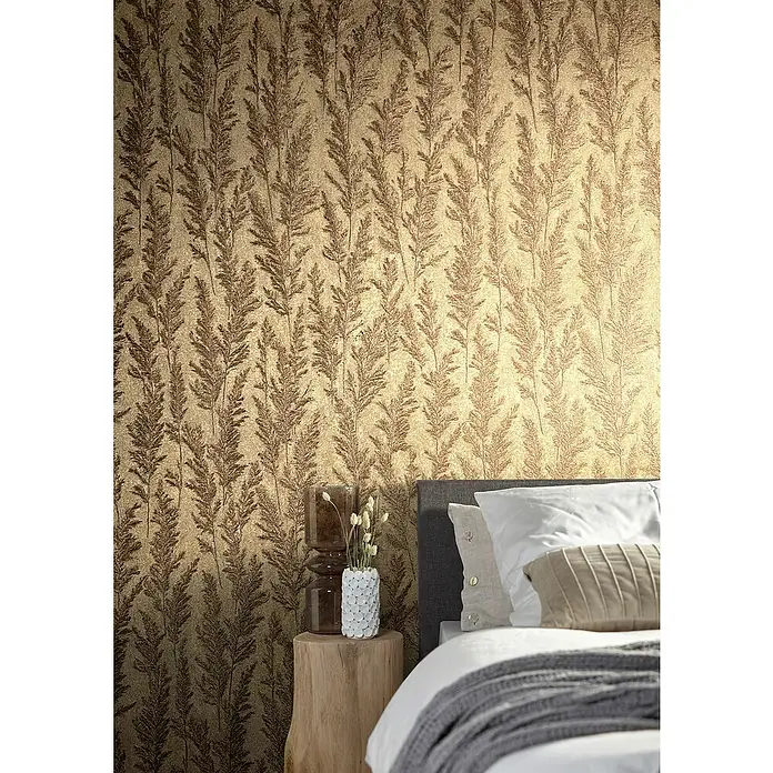 Marburg Natural Opulence Vliestapete Weiche Gräser - Gold, Floral, 10,05 x 0,7 m - Nahaufnahme einer Wandtapete mit einem dezenten Blattmuster in Goldbraun, ideal für eine elegante Schlafzimmergestaltung.
