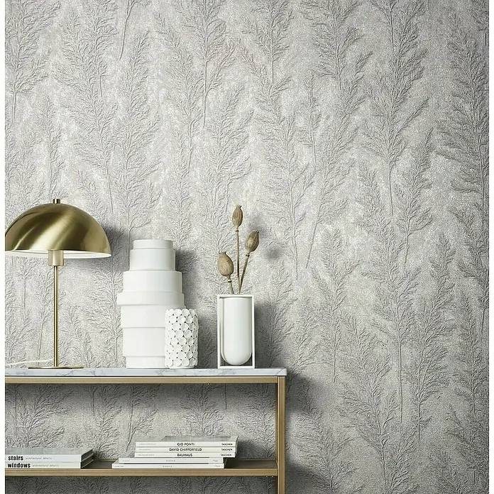 Marburg Natural Opulence Vliestapete Weiche Gräser - Grau, Floral, 10,05 x 0,7 m - Ein stilvolles Interieur mit einer goldenen Lampe und dekorativen Vasen auf einem Tisch vor einer botanischen Tapete.