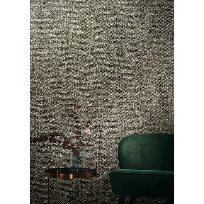 Marburg Natural Opulence Vliestapete - Beige-Braun, Uni, 10,05 x 0,7 m - Nahaufnahme eines stilvollen grünen Sessels vor einer texturierten Wand, neben einem eleganten Beistelltisch mit floralem Dekor.