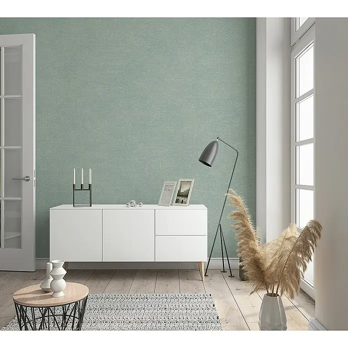 Marburg Shades Vliestapete - Grün, Uni, 10,05 x 0,53 m - Modernes Wohnzimmer mit weißem Sideboard, Stehlampe und Dekorationselementen.