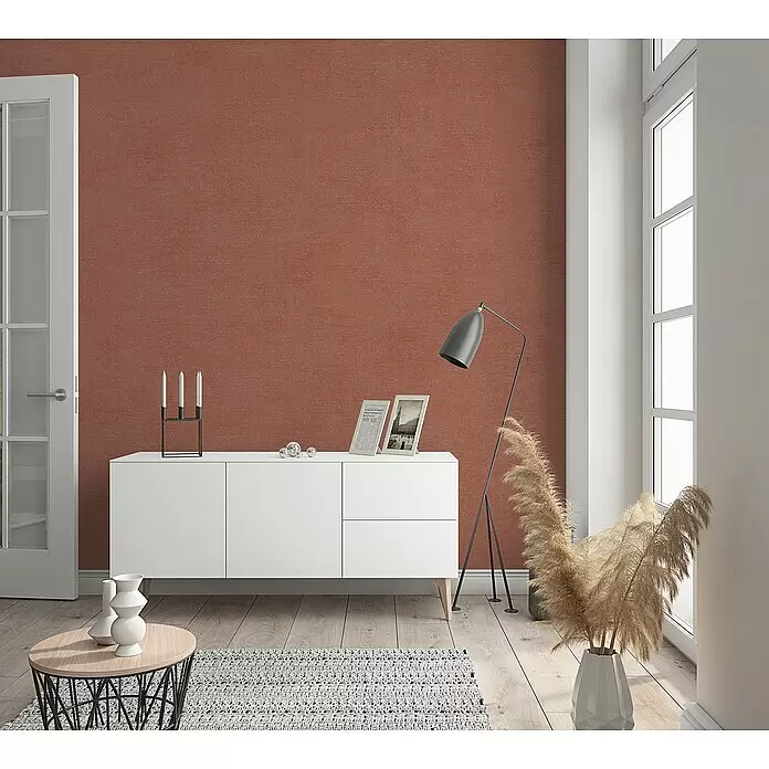 Marburg Shades Vliestapete - Rot-Orange, Uni, 10,05 x 0,53 m - Rotbraune strukturierte Tapete an einer Wand in einem modernen Raum.