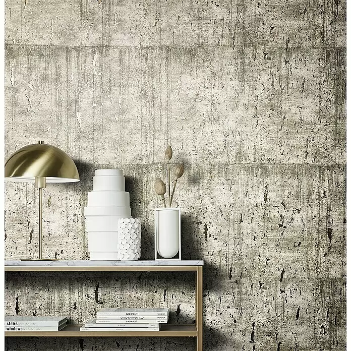 Marburg Natural Opulence Vliestapete - Helles Greige, Betonoptik, 10,05 x 0,7 m - Hellgraue Wand mit abblätternder Putz- oder Betonoptik, als Hintergrund für ein Regal mit Deko und Büchern.
