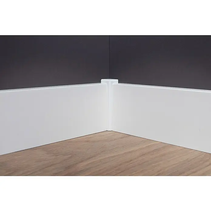 Sockelleiste - 240 cm x 16 mm x 70 mm, Fichte, Lackiert - Weißer Sockelleistenstoßverbinder an einer Innenecke mit grau gestrichenen Wänden und Holzboden. Saubere und moderne Verarbeitung.